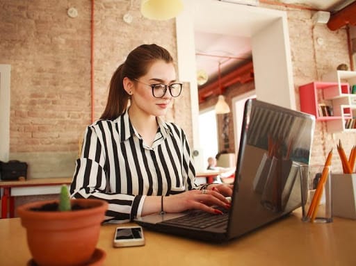 An employee works on her computer creating backlinks for a client.